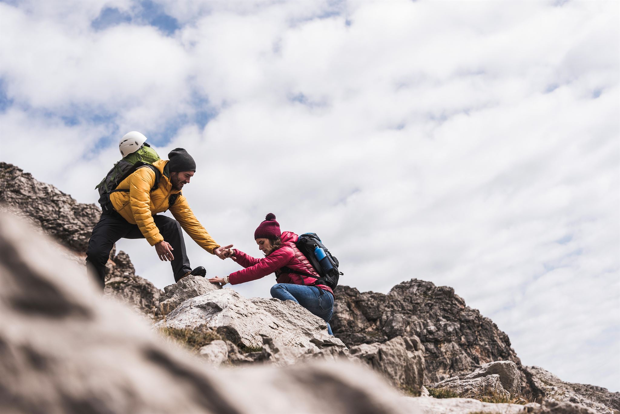 One-person-helping-other-person-climb-up-a-rock